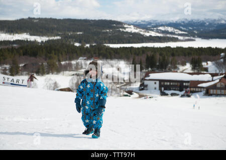 Junge Kind zu Fuß spielen in den verschneiten Berg im Winter Wonderland Stockfoto