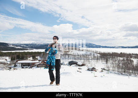 Vater Sohn spielen in den verschneiten Berg im Winter Wonderland Stockfoto