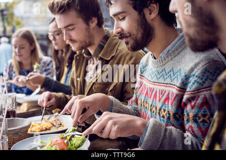Männliche und weibliche Freunde Mittagessen im Restaurant im Freien Stockfoto