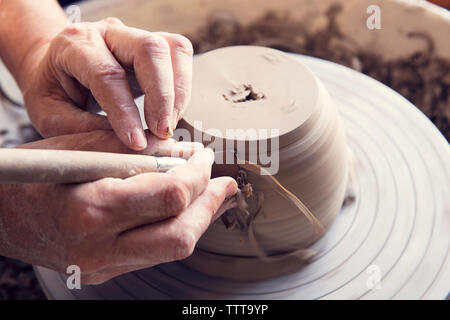 7/8 Bild der Frau molding Form mit Werkzeug auf Keramik rad Ton Stockfoto