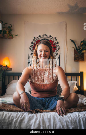 Portrait von fröhlichen Künstler sitzen auf dem Bett zu Hause. Stockfoto