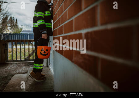 Niedrige Abschnitt der Boy holding Halloween Schaufel beim Stehen an der Tür Stockfoto