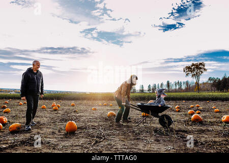 Familie an Pumpkin Patch gegen bewölkter Himmel Stockfoto