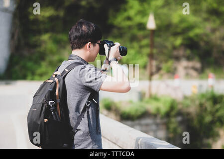 Unspezifische Mann mit einer Kamera in den Händen Spaziergänge rund um die Stadt und Fotografien der Stadt und der Bevölkerung für die Nachrichten. Stockfoto