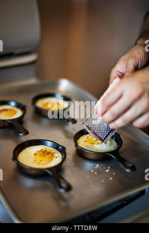 Mann Gitter Käse auf die Hälfte Spiegeleier auf Blech Stockfoto