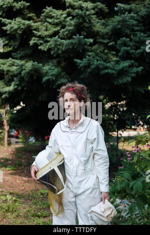 Portrait von zuversichtlich senior Imker das Tragen von Schutzkleidung auf Feld Stockfoto