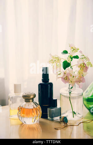 Beauty Produkte mit Schmuck von Blumenvase auf dem Tisch arrangiert Stockfoto