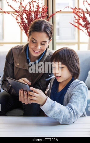 Lehrer mit Schüler über Tablet-PC im Zimmer während der Exkursion Stockfoto