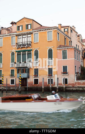 Italien, Venedig. Ein Wassertaxi vergeht vor einem Haus entlang der Grand Canal. Stockfoto