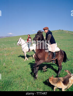 Spanien, Andalusien, Tarifa, reifer Mann und eine Frau Reiten auf einem Hügel Stockfoto