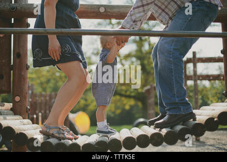 Happy Family springen auf Holzbrücke in Spielplatz Stockfoto