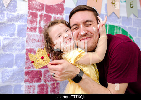 Mädchen umarmt Vater während Prinzessin party Stockfoto