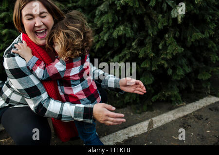 Hohe Betrachtungswinkel der Sohn umarmen fröhliche Mutter im Garten Center Stockfoto