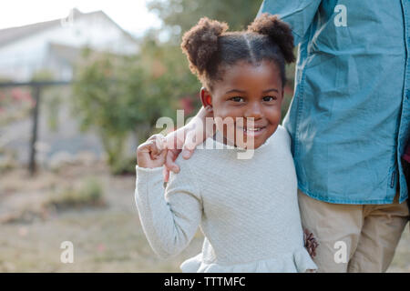 Porträt der lächelnde Mädchen stehend mit Bruder Stockfoto