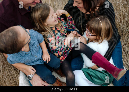 Hohe Betrachtungswinkel der glücklichen Familie sitzt auf der Wiese Stockfoto