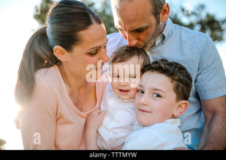 Low Angle View der glücklichen Familie, die draußen bei Sonnenuntergang Stockfoto