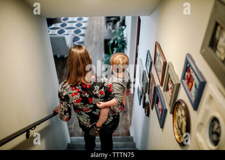 Ansicht der Rückseite des Mutter mit Sohn beim Gehen hinunter Schritte zu Hause Stockfoto