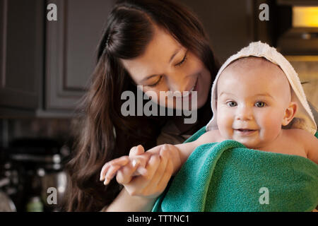 Mutter Holding Baby in Handtücher zu Hause gewickelt Stockfoto