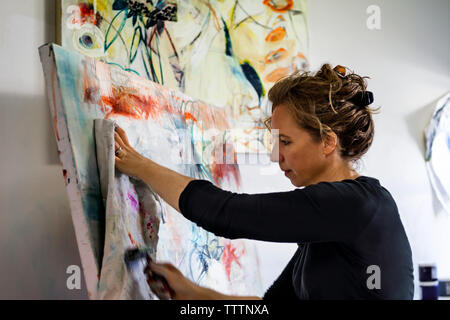 Frau mit paint Roller und Stoff beim Malen Stockfoto