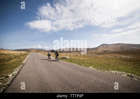 Ansicht der Rückseite des Freunde Reiten Fahrrad gegen Sky Stockfoto
