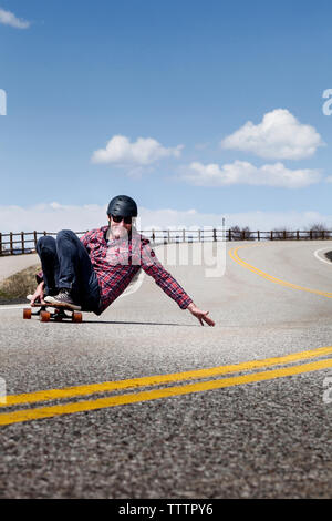 Mann skateboarding auf der Straße gegen den Himmel Stockfoto