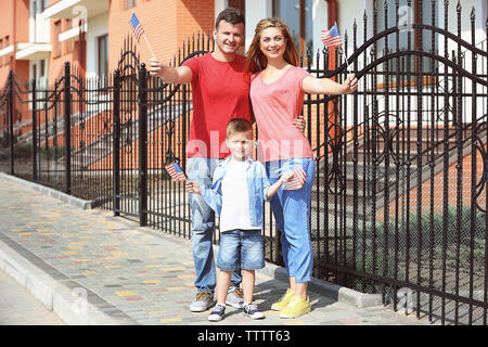 Glückliche Familie mit amerikanischen Flaggen im Hof Stockfoto