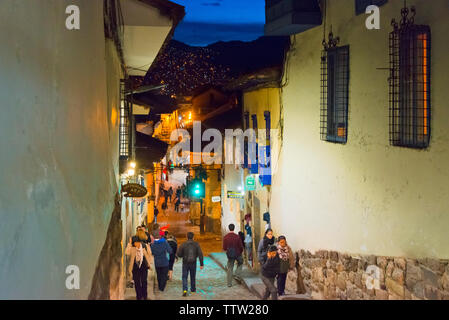 Menschen zu Fuß auf gepflasterten Straße mit Häusern im Kolonialstil in der Nacht gefüttert, Cusco, Peru Stockfoto