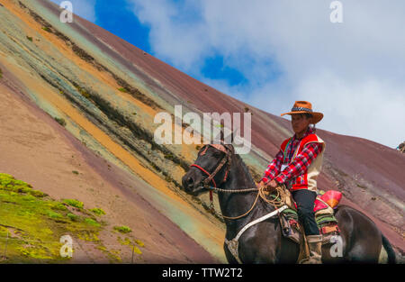 Quechua Mann reiten auf Pferd in Rainbow Mountain (Vinicunca), Cusco Region, Peru Stockfoto