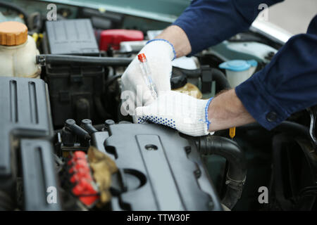 Mechaniker Hände in Handschuhe Reparatur Auto in die Motorhaube öffnen Stockfoto