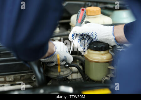 Mechaniker Hände in Handschuhe Reparatur Auto in die Motorhaube öffnen Stockfoto