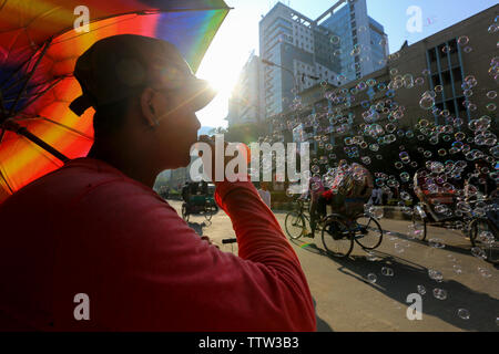 Eine Hawker bläst Seifenblasen am Straßenrand anlässlich des Eid ul Azha. Dhaka, Bangladesch. Stockfoto