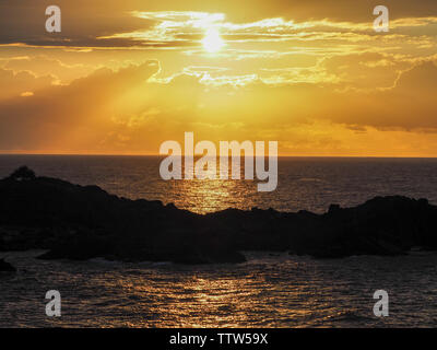 Golden Sawtell Sonnenaufgang, mit Horizont trennt Ozean und Himmel, gelbes Sonnenlicht scheint durch die glühenden Wolken reflektieren auf dem Meer Australien Stockfoto