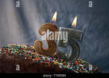 Geburtstag Kuchen mit brennenden Kerzen auf grauem Hintergrund Stockfoto