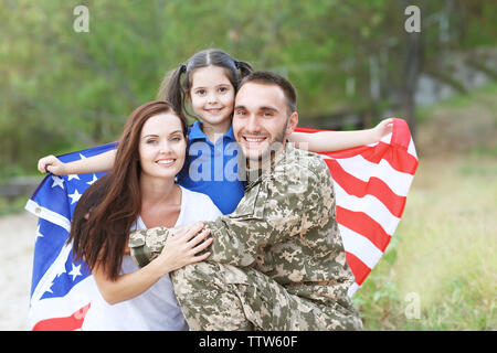 US-Armee Soldaten mit Familie und USA-Flagge in Park Stockfoto