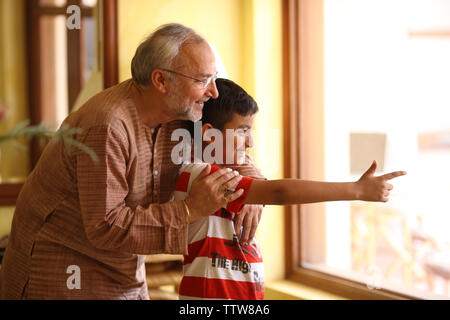 Indische alter Mann mit seinem Enkel Blick durch die Fenster Stockfoto