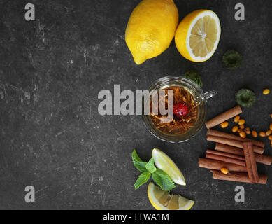 Frische leckere Tee Zutaten und Beeren auf grauem Hintergrund Stockfoto