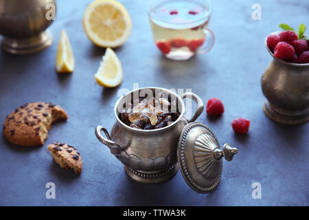 Metal pot mit braunem Zucker und Kaffee auf Tisch Stockfoto