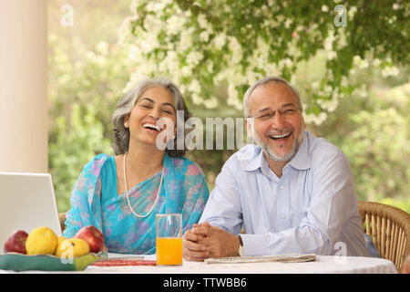 Alten Ehepaar sitzt am Frühstückstisch und lächelnd Stockfoto