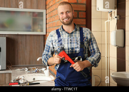 Portrait von gutaussehenden Klempner mit einer Rohrzange Stockfoto
