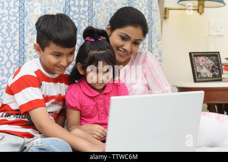 Frau mit ihren Kindern an einem Notebook arbeitet Stockfoto