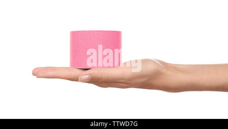 Weibliche Hand, die eine spezielle Physio Tape Rolle auf weißem Hintergrund Stockfoto