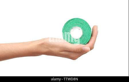 Weibliche Hand, die eine spezielle Physio Tape Rolle auf weißem Hintergrund Stockfoto