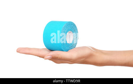 Weibliche Hand, die eine spezielle Physio Tape Rolle auf weißem Hintergrund Stockfoto