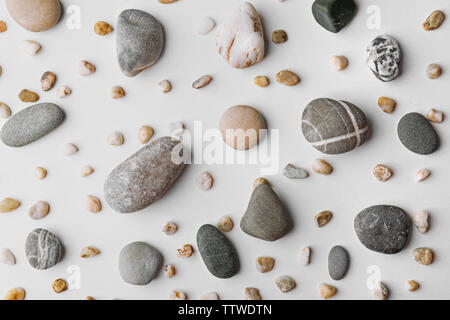 Streuung von großen und kleinen Steinchen auf weißem Hintergrund Stockfoto