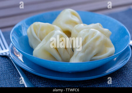 Georgische Knödel Khinkali mit Fleisch auf blauen Platte Nahaufnahme Stockfoto