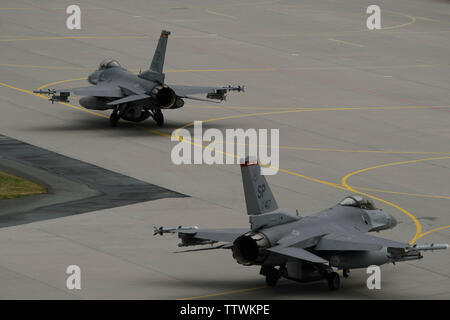 Zwei F-16 Fighting Falcons der Expeditionary 480th Fighter Squadron Taxi hinunter die flightline während der Luftfahrt Rotation 19-2 bei Krzesiny Air Base, Polen, 13. Juni 2019 vergeben. Diese Übung bietet die bilateralen Training Partner, die Interoperabilität zu verbessern, pflegen gemeinsame Bereitschaft und Verbündeten in der Region zu gewährleisten. (U.S. Air Force Foto: Staff Sgt. Jonathan Snyder) Stockfoto