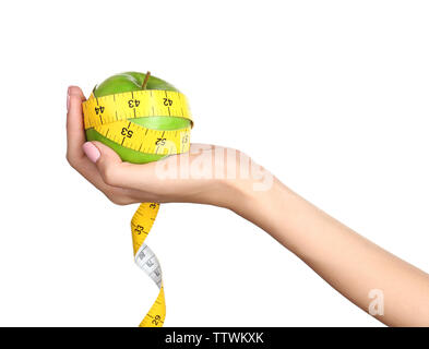 Weibliche Hand, die Apple mit Maßband auf weißem Hintergrund Stockfoto