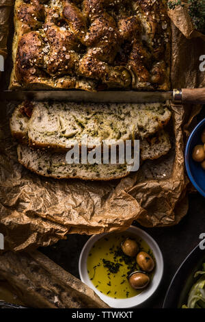 In der Nähe von frisch gebackenem Brot, hausgemachten Focaccia mit Oliven öl, Ansicht von oben. Traditionelle italienische Brot. Authentische italienische Küche Konzept. Dunkel. Rustikale Stockfoto