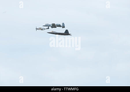 Eine P-51 Mustang, A-10 Thunderbolt II und F-22 Raptor fliegen in Formation über Whiteman Air Force Base, Missouri, am 16. Juni 2019. Das Flugzeug ein Erbe Demonstration während der 2019 Flügel über Whiteman für Luft- und Raumfahrt zeigen. (U.S. Air Force Foto: Staff Sgt. Kayla Weiß) Stockfoto