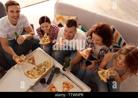 Freunde sitzen auf der Couch und Essen lecker Pizza Stockfoto
